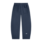 A pair of navy blue sweatpants with an elastic waistband, a side pocket on the right hip, and a small white logo on the lower left leg, shown against a plain white background.