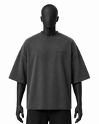 A dark gray washed short-sleeve t-shirt displayed on a matte black mannequin against a solid white background. The shirt features a small black script logo on the left chest.